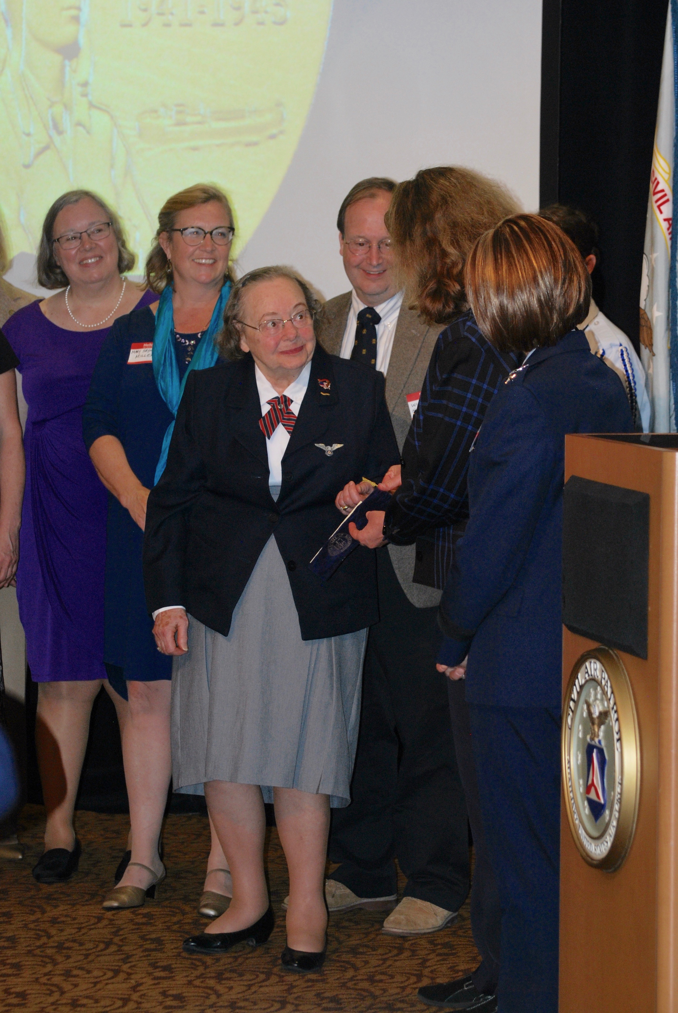 Surrounded by family, friends, and local dignitaries including Honorable Allison Silberberg, City of Alexandria Mayor, and Vivian Watts, delegate for Virginia’s 39th district, Elizabeth “Libby” Haynes receives the Congressional Gold Medal