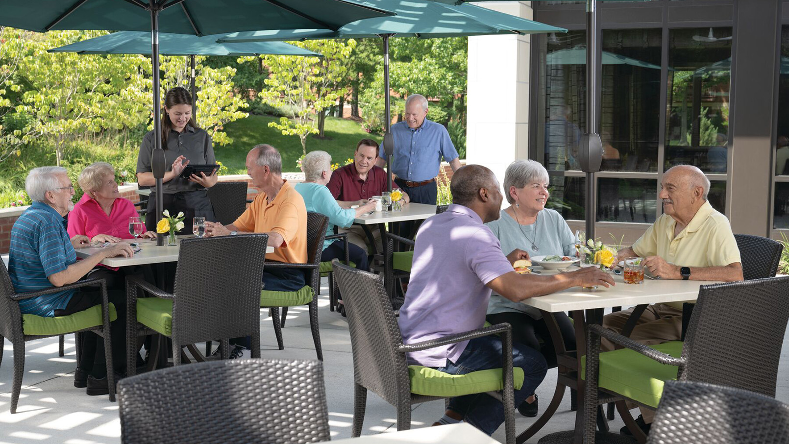 Residents savoring a meal together in the fresh air of our senior living community's outdoor dining area.